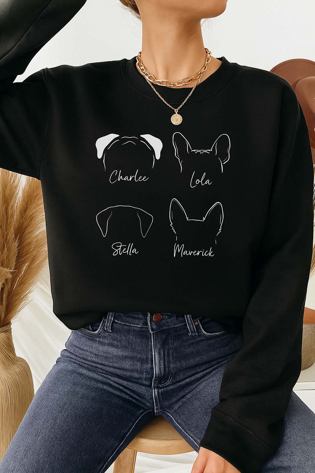 Woman wearing black personalized dog sweatshirt featuring four pet ear outlines and names, casual cozy outfit with jeans, dog lover clothing gift.