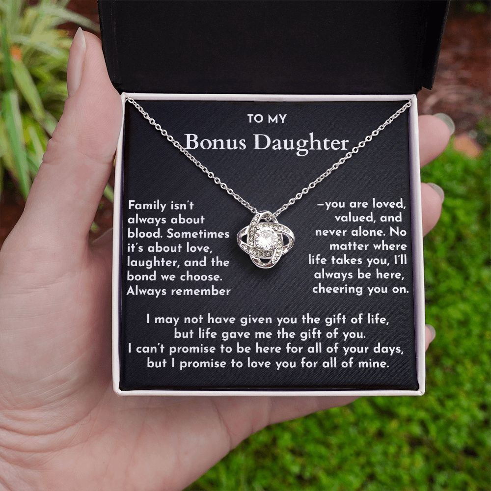 Necklace with a sentimental message card held by a hand against a natural background
