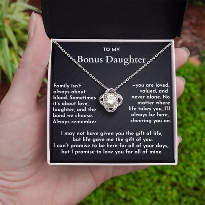 Necklace with a sentimental message card held by a hand against a natural background
