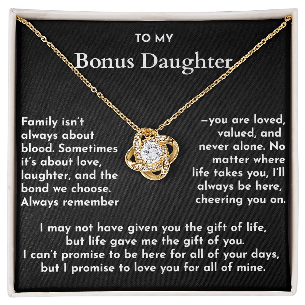 Gold necklace with a heart-shaped pendant on a black card with text for a bonus daughter.