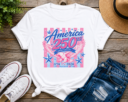 White t-shirt with 'America 250th Anniversary' design on a wooden surface with shoes and jeans.