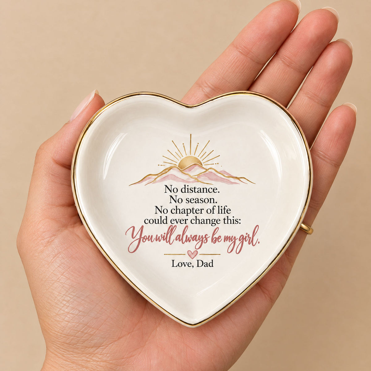 Small heart-shaped ceramic jewelry dish resting in a woman's palm, showing its size and sentimental message from Dad.