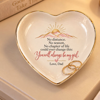 Heart-shaped white ceramic dish with gold trim, featuring a printed mountain sun design and the message 'No distance. No season.