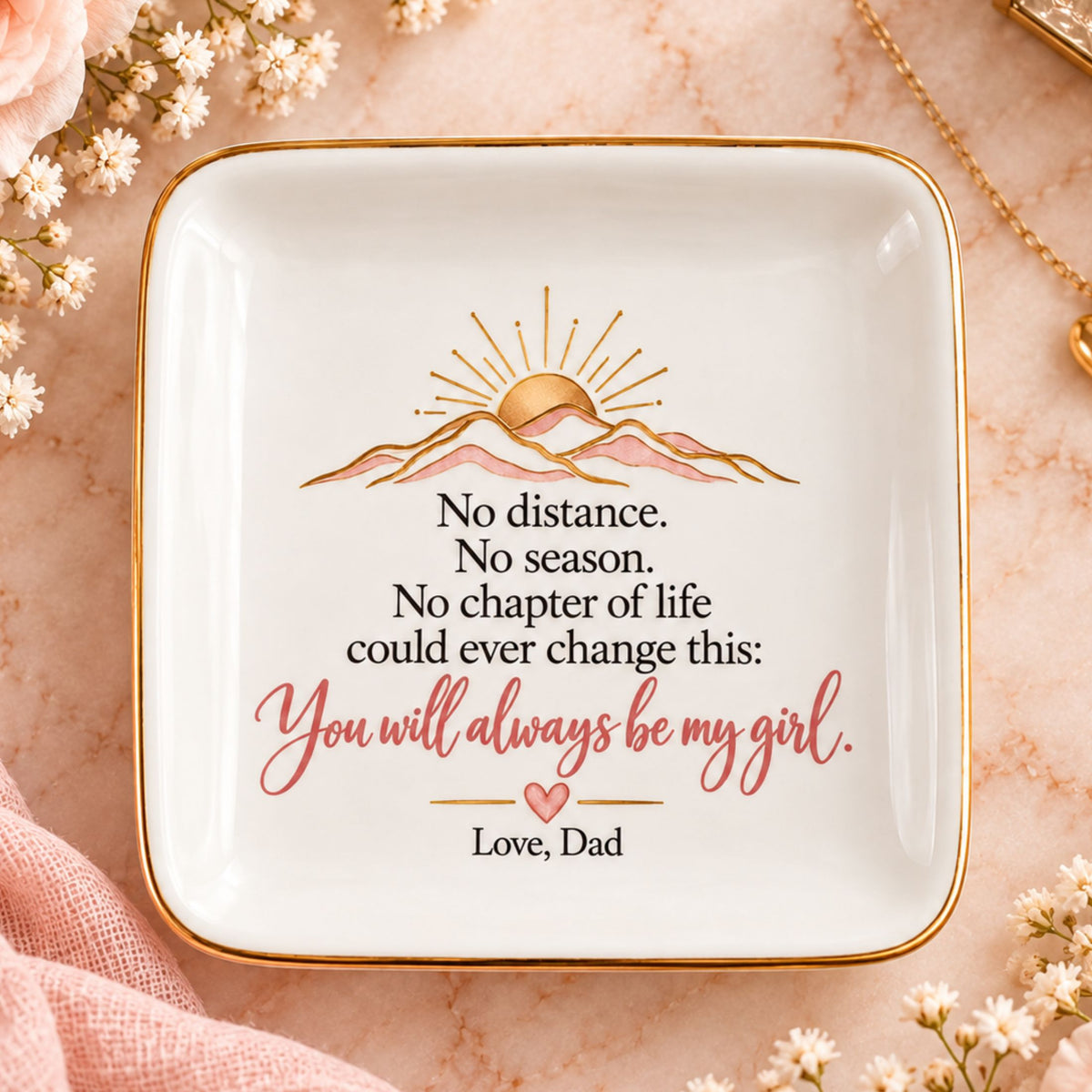 A square white ceramic dish with rounded corners, featuring a gold border and a printed message for Dad. The design includes a gold sun over pink mountains, with the text 'No distance.